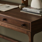 Close up of Four Hands Arturo Desk in Natural Walnut Veneer in a modern office with green walls