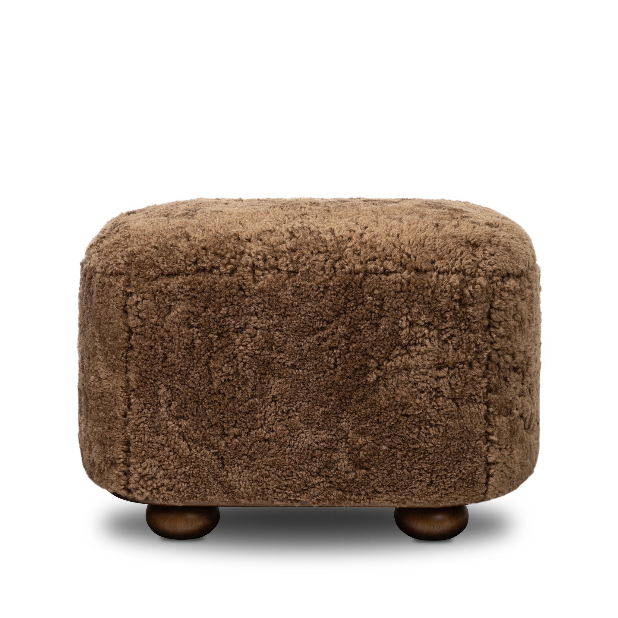 Four Hands Bilbury Oval Ottoman in Amber Shearling on white background at Addison West.