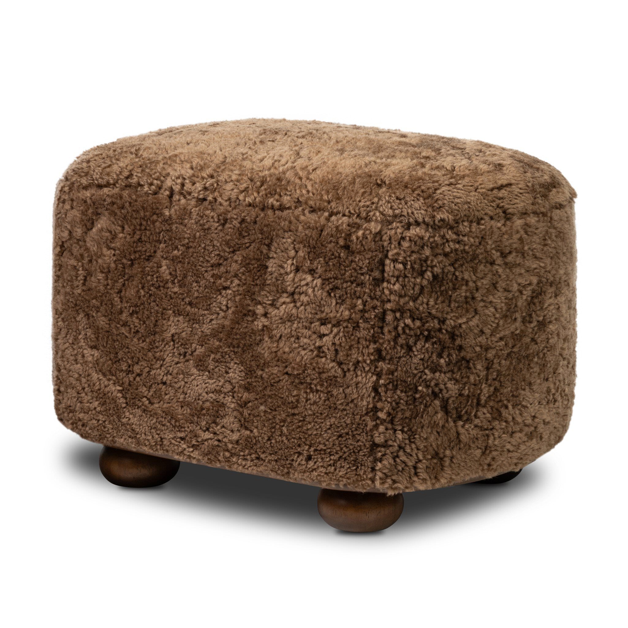 Four Hands Bilbury Oval Ottoman in Amber Shearling on white background at Addison West.