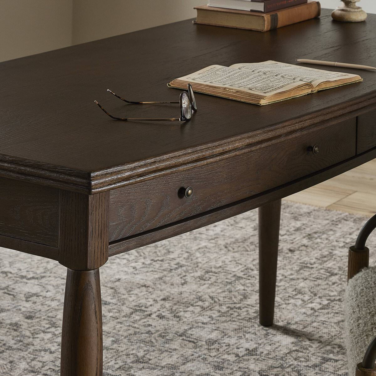 Close up of Four Hands Bowfront Desk in Drifted Oak Veneer in an office at Addison West