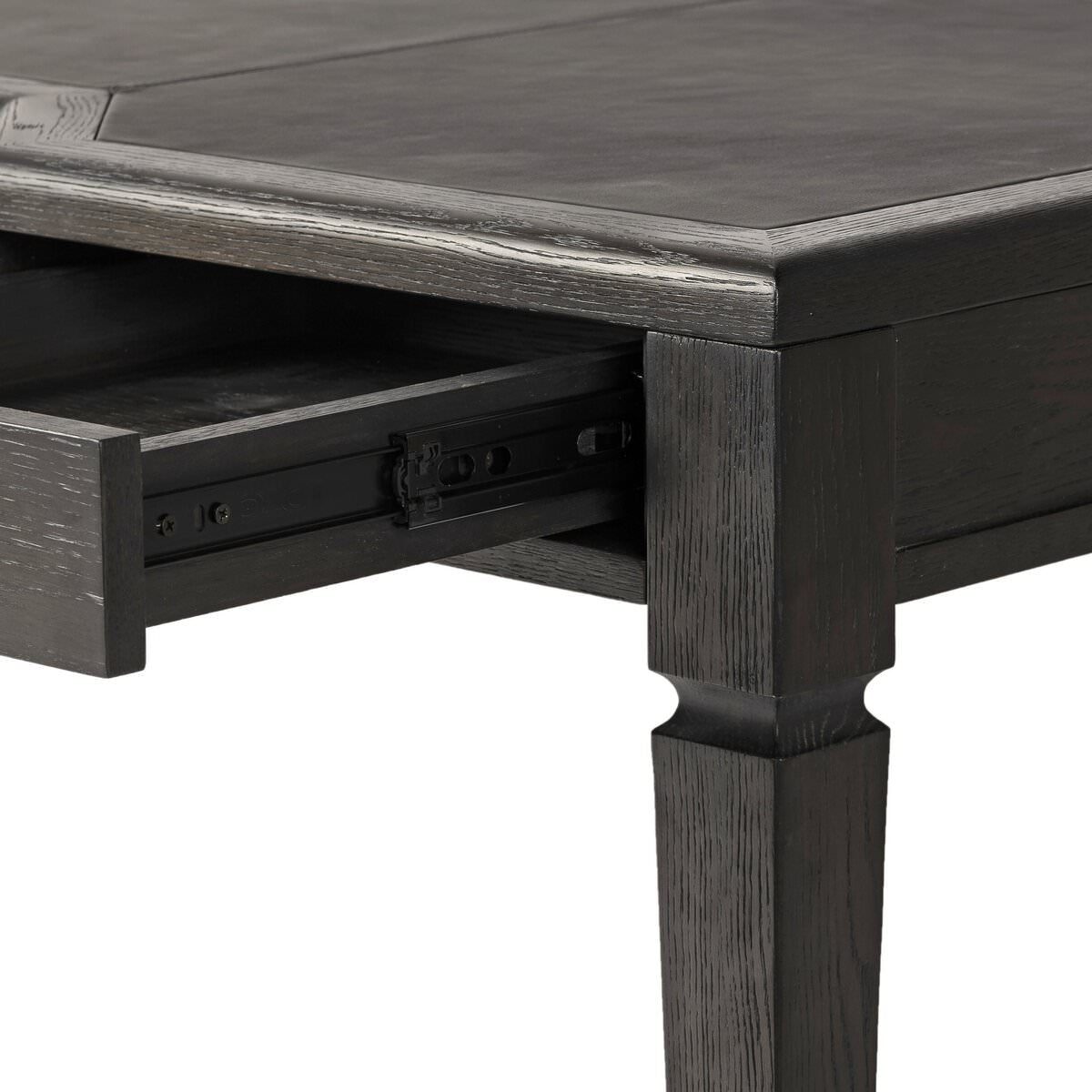 Close up of Four Hands Claude Desk in Distressed Black Oak Veneer on a white background at Addison West