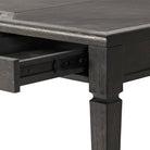 Close up of Four Hands Claude Desk in Distressed Black Oak Veneer on a white background at Addison West