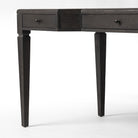 Close up of Four Hands Claude Desk in Distressed Black Oak Veneer on a white background at Addison West