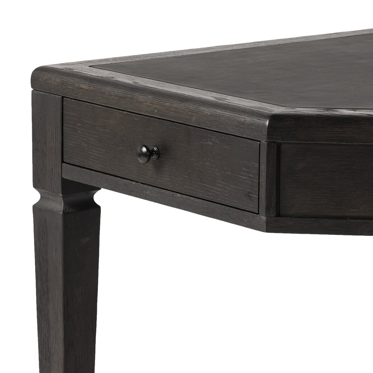 Close up of Four Hands Claude Desk in Distressed Black Oak Veneer on a white background at Addison West