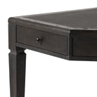 Close up of Four Hands Claude Desk in Distressed Black Oak Veneer on a white background at Addison West