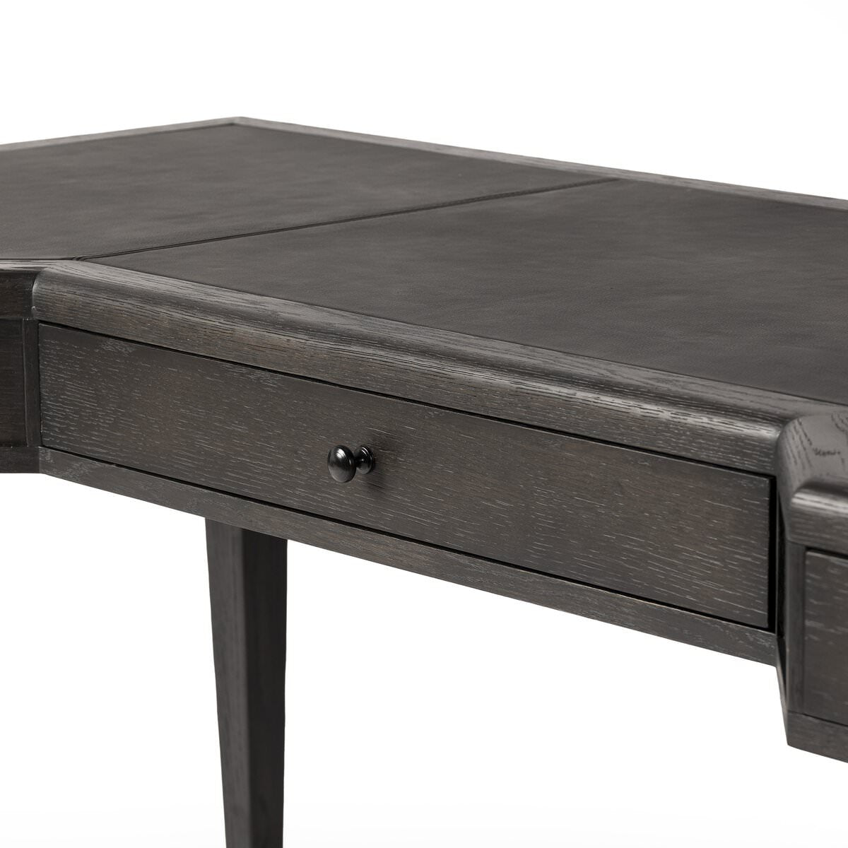 Close up of Four Hands Claude Desk in Distressed Black Oak Veneer on a white background at Addison West