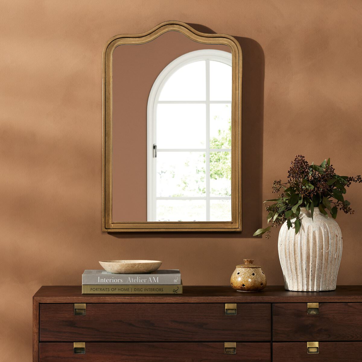Four Hands Effie Mirror in Raw Antique Brass in a living room at Addison West