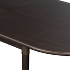 Close up of Four Hands Harper Oval Extension Dining Table 84-104" in Black Mango Veneer on a white background at Addison West
