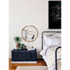 Four Hands Iron Casey Bed in Black in a room with wood floors and white painted brick