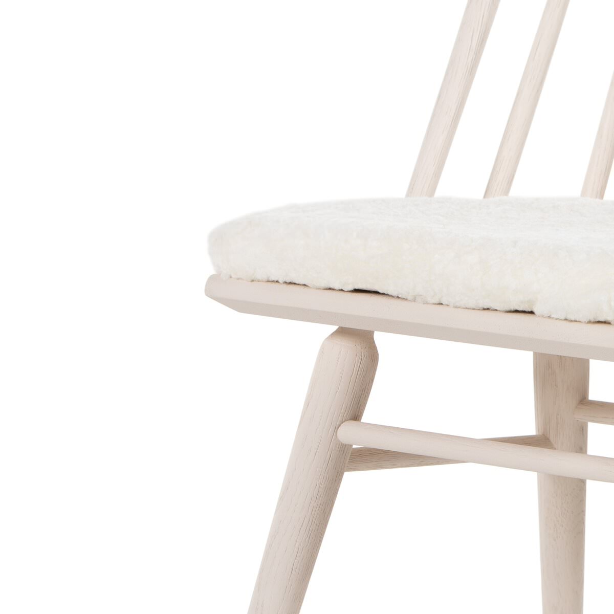 Close up of Four Hands Lewis Windsor Chair in Cream Shorn Sheepskin on a white background