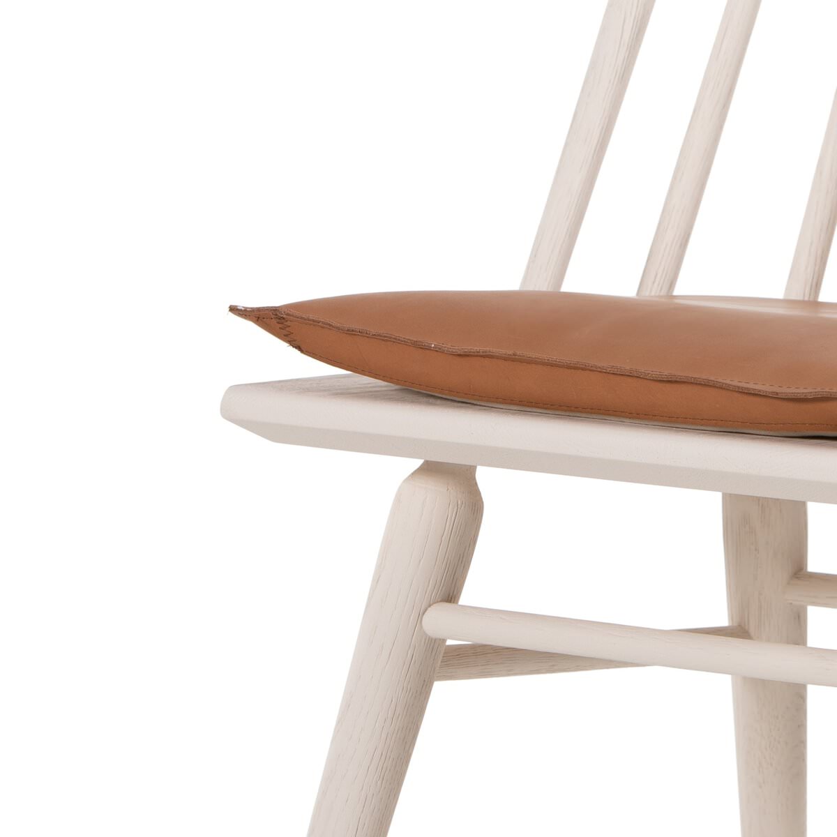 Close up of Four Hands Lewis Windsor Chair in Off White Whiskey Saddle on a white background