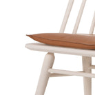 Close up of Four Hands Lewis Windsor Chair in Off White Whiskey Saddle on a white background