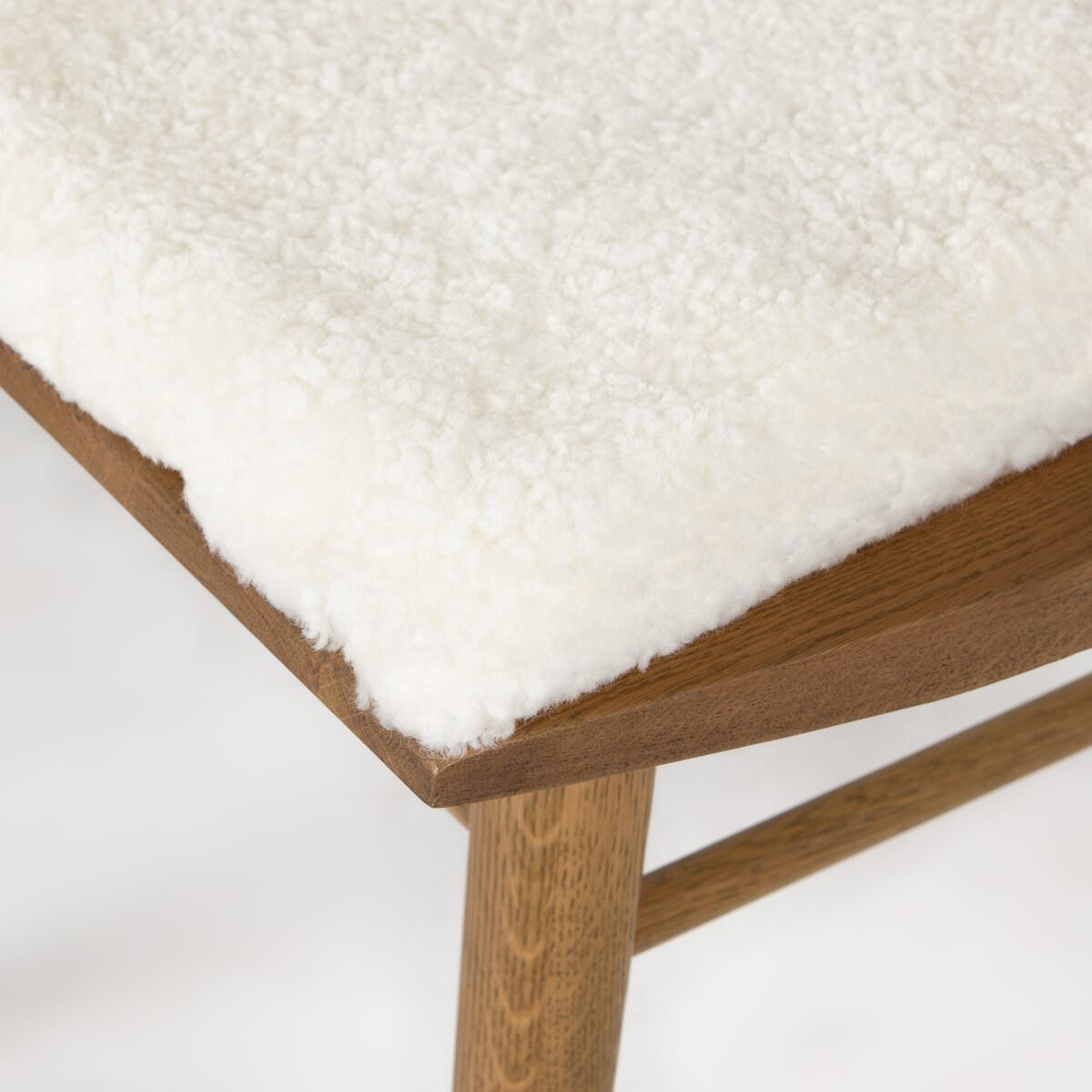 Close up of Four Hands Lewis Windsor Chair in Sandy Oak Shorn Sheepskin on a white background