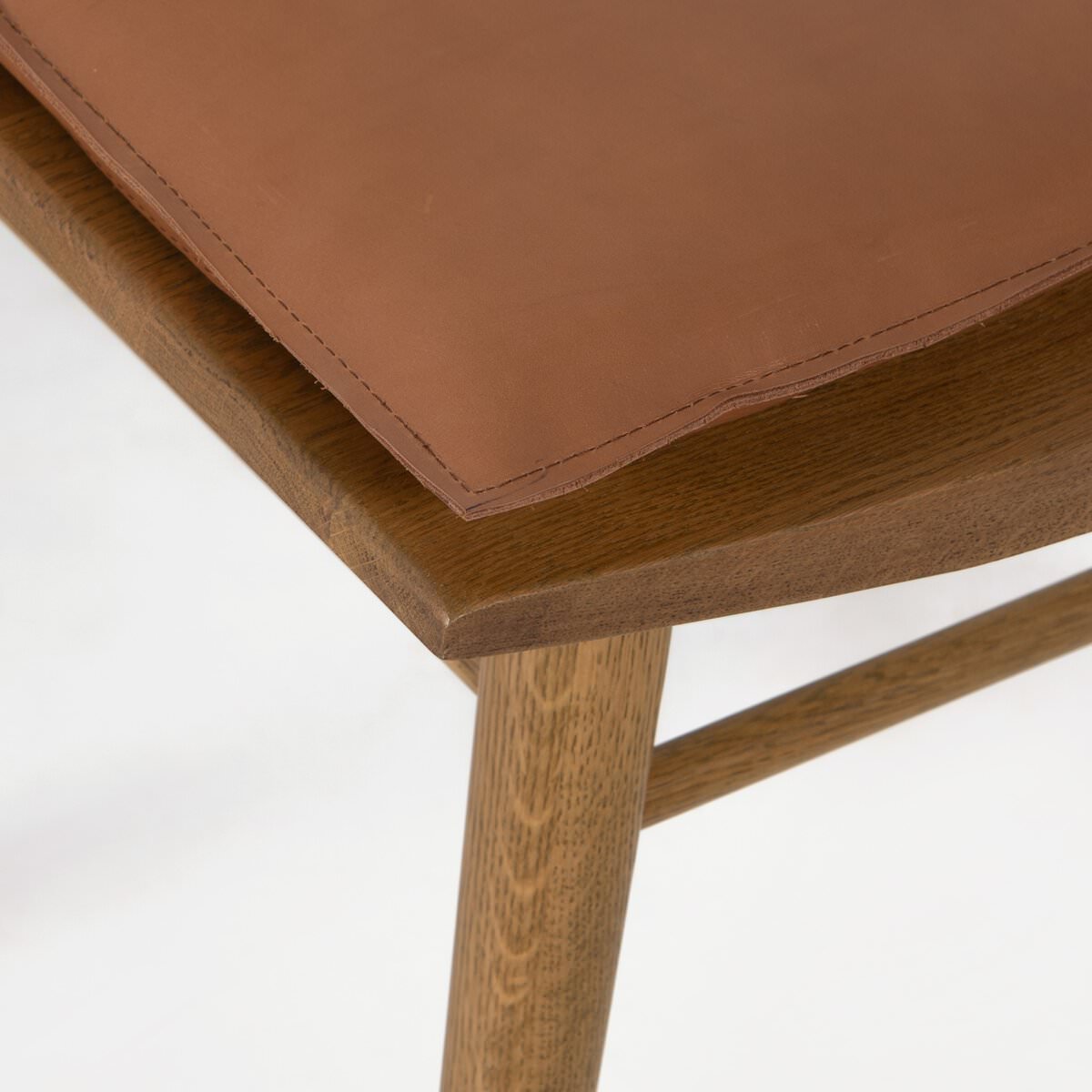 Close up of Four Hands Lewis Windsor Chair in Sandy Oak Whiskey Saddle on a white background