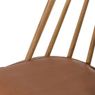 Close up of Four Hands Lewis Windsor Chair in Sandy Oak Whiskey Saddle on a white background