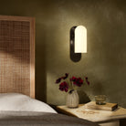Four Hands Odyssey Sconce in Black Gunmetal with Opal Matte Glass in bedroom at Addison West.