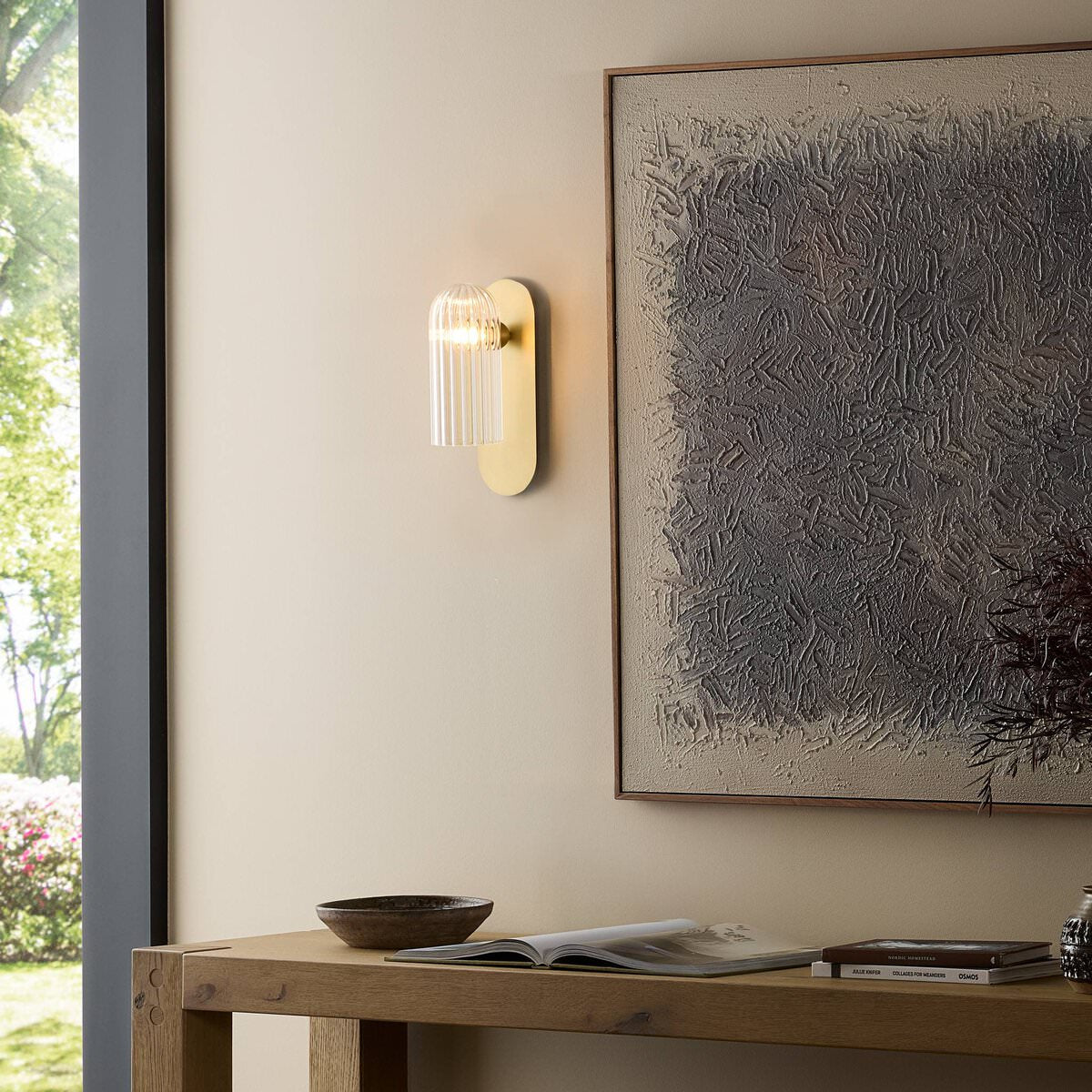 Four Hands Odyssey Sconce in Burnished Brass on a wall at Addison West