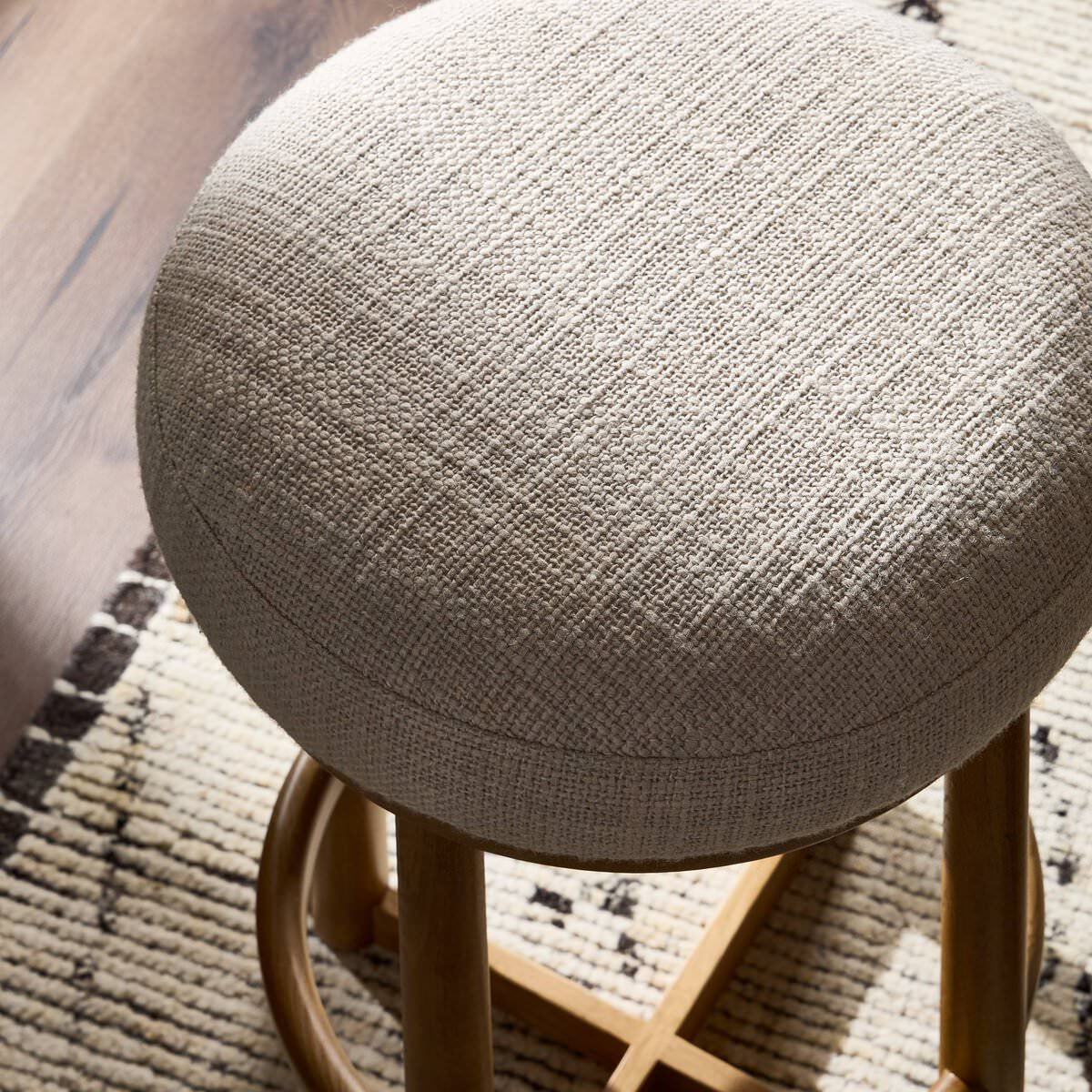 Close up of Four Hands Staria Swivel Counter Stool in Saxon Sand in a dining room at Addison West
