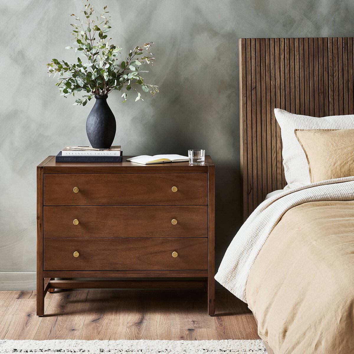 Four Hands Sullivan Nightstand in Saddle Tan Veneer in a modern bedroom with dark walls
