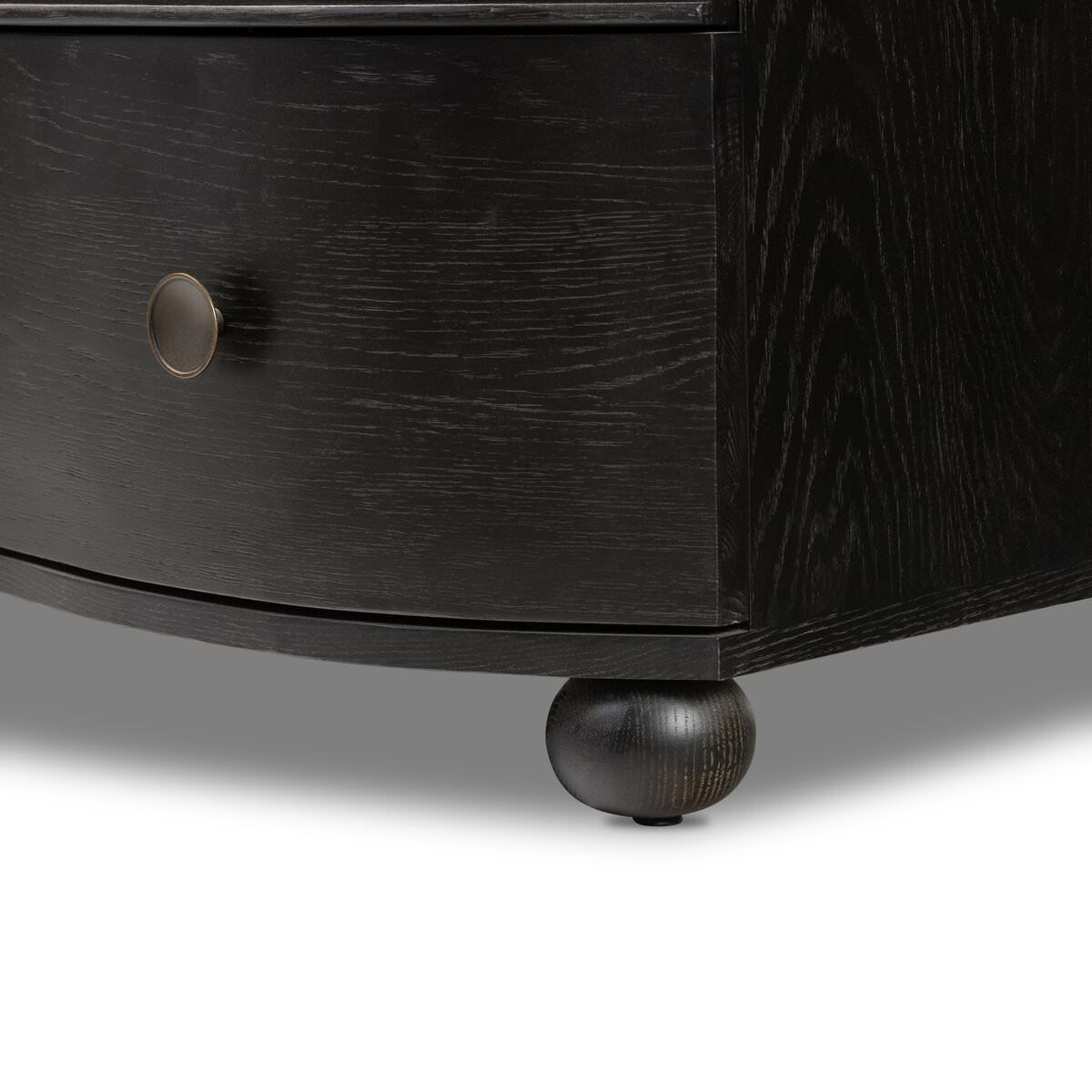 Close up of the feet of Four Hands Tiago Marble Chest in Distressed Black on a white background
