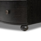 Close up of the feet of Four Hands Tiago Marble Chest in Distressed Black on a white background
