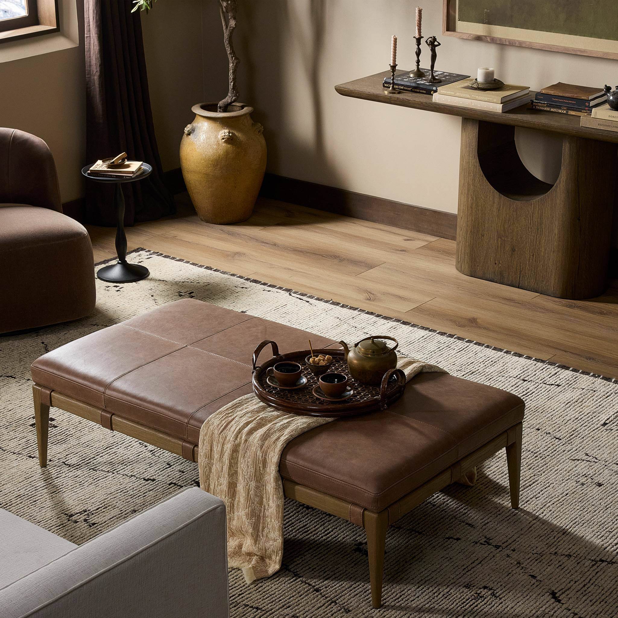 Four Hands Ulrick Ottoman Palermo Cigar in living room at Addison West.