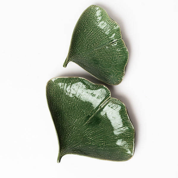 Set of two green gingko leaf plates on a white background