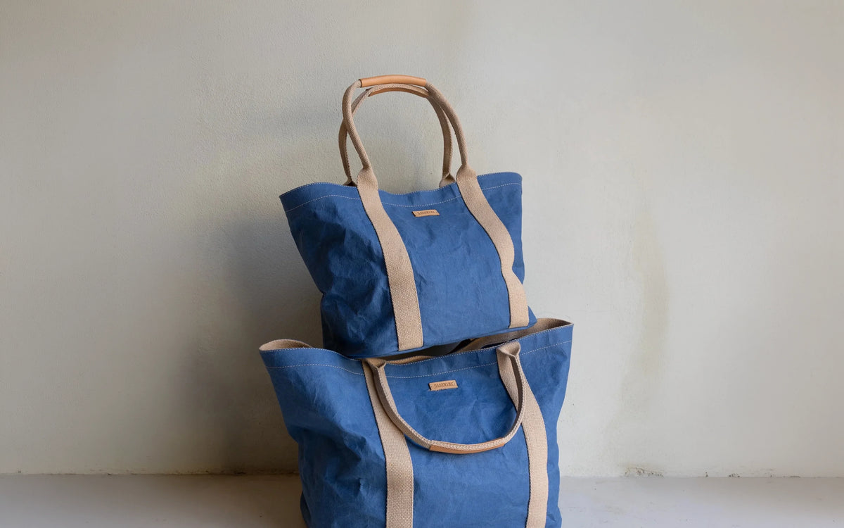 Blue and tan totes bags on a beige background