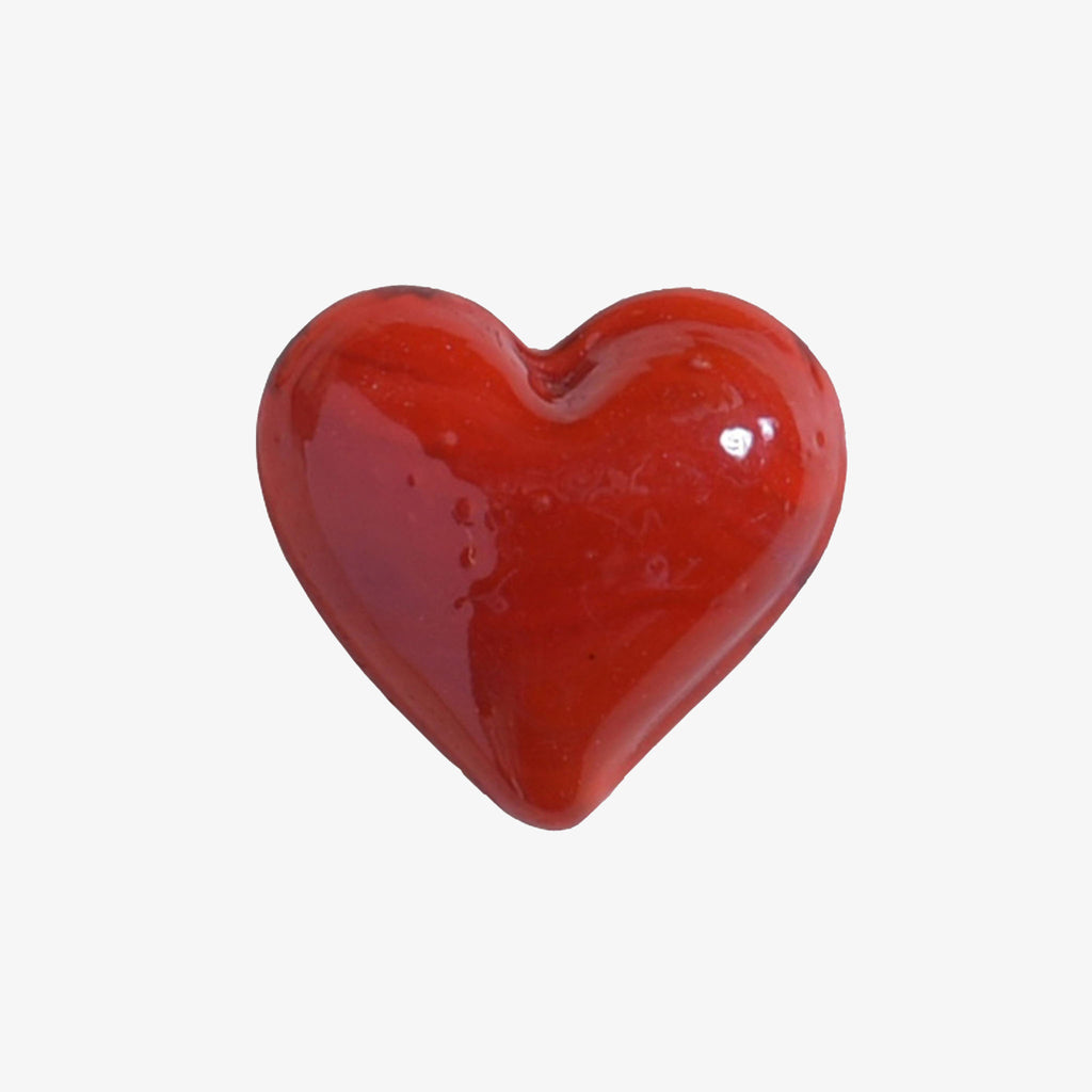 Small red glass heart on a white background