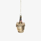 A glass ice bucket with a champagne bottle inside, designed as a holiday ornament, intended to be hung