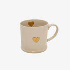 White ceramic mug with gold painted heart on front and inside of cup on a white bacground