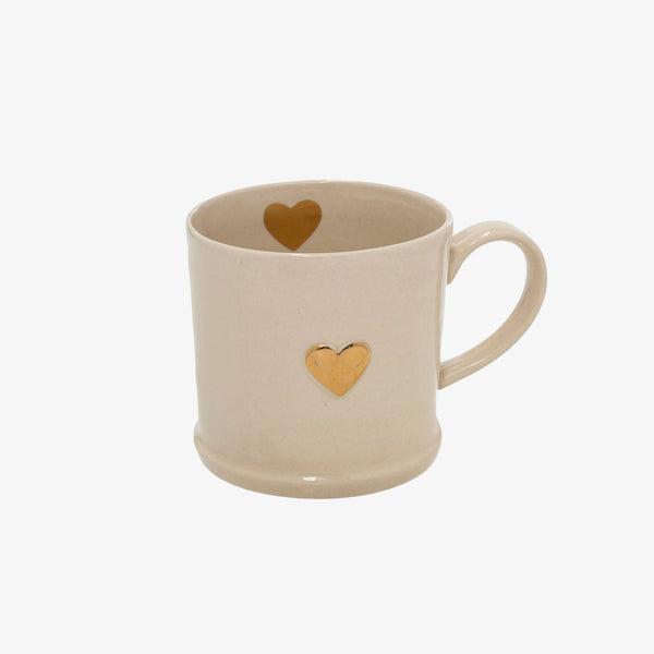 White ceramic mug with gold painted heart on front and inside of cup on a white bacground