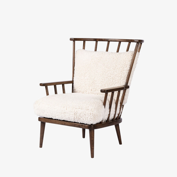 Four Hands Graham Chair with spindle back and shearling cushions on a white background