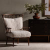 Four Hands Graham Chair with spindle back and shearling cushions in Andes Natural in a moody living space with grey walls
