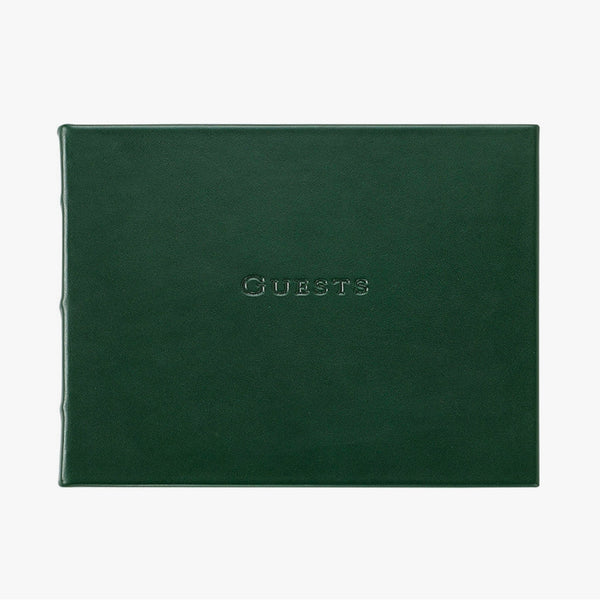 Green leather bound guest book on a white background