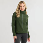 DWoman wearing Dudley Stevens Heyward Vello Fleece Turtleneck in Spruce sweater with dark colored pants on a plain background.