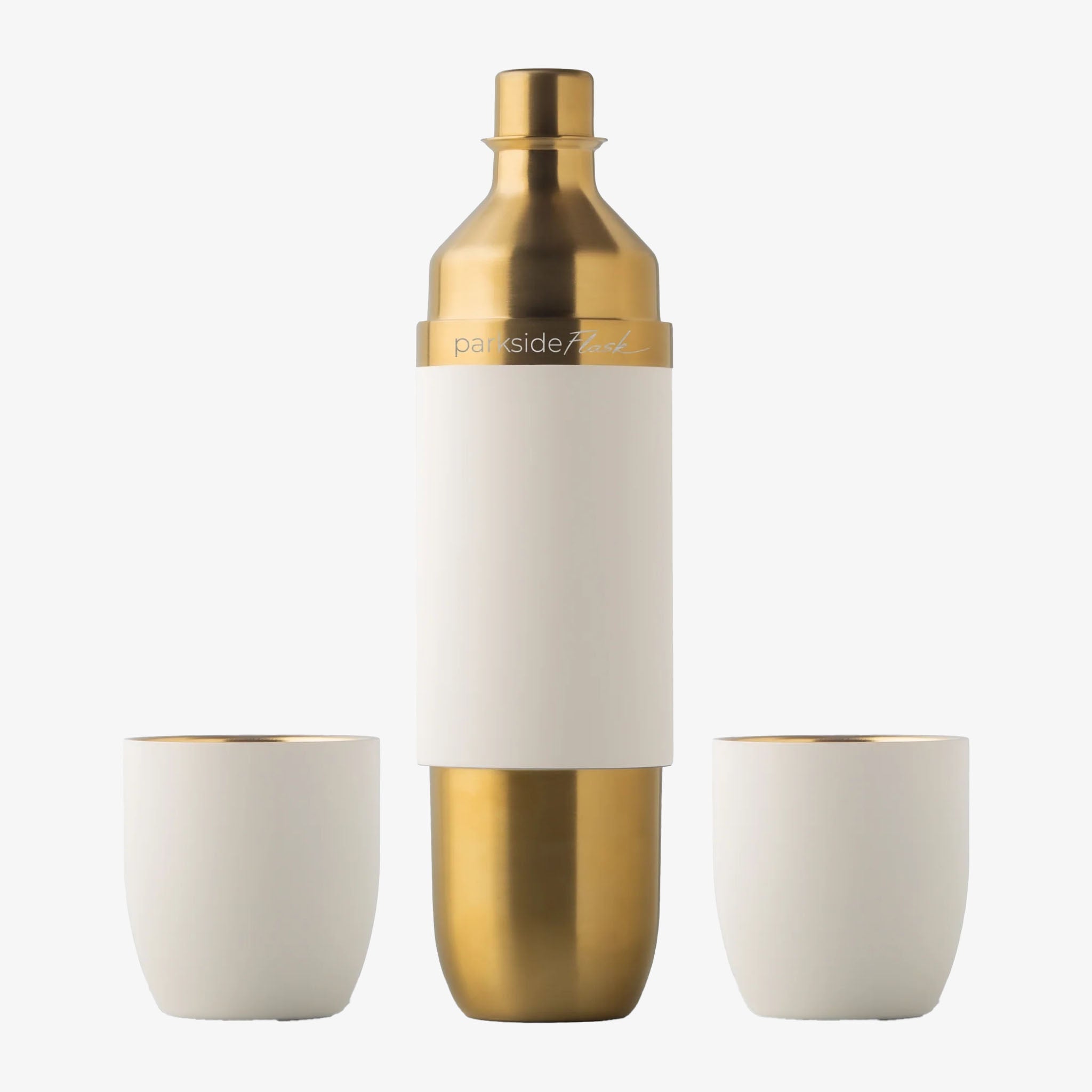 A stainless steel flask with gold and white coloring, accompanied by two white tumblers, against a white background.