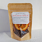 A stand-up pouch of Growtop Germs 'Blend' Holiday Spice, featuring a kraft paper design, a white label with red and black text, and a clear window showing dried orange slices and whole spices inside, set against a white textured background.