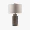Neutral textured table lamp with linen shade on a white background