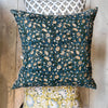 Filling spaces Izna square throw pillow on a wood floor with other complementary pillows