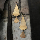 Tiny Anvil Brass Lantern Earrings on a grey background at Addison West