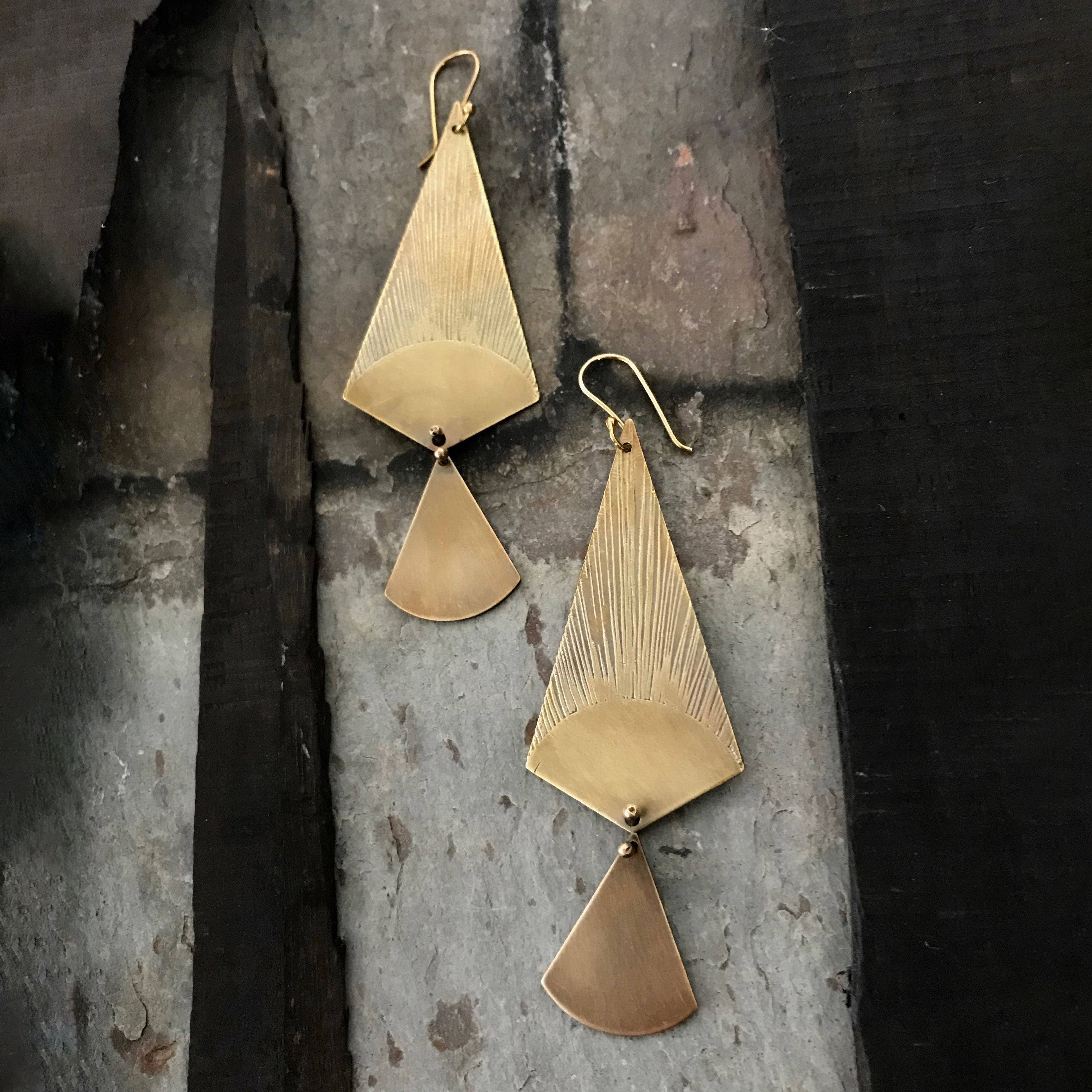Tiny Anvil Brass Lantern Earrings on a grey background at Addison West