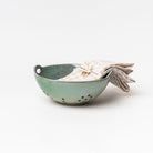 Blue Green glazed berry bowl with plaid napkin on a white background