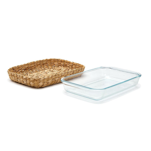 Glass baking dish with removable seagrass sleeve on a white background