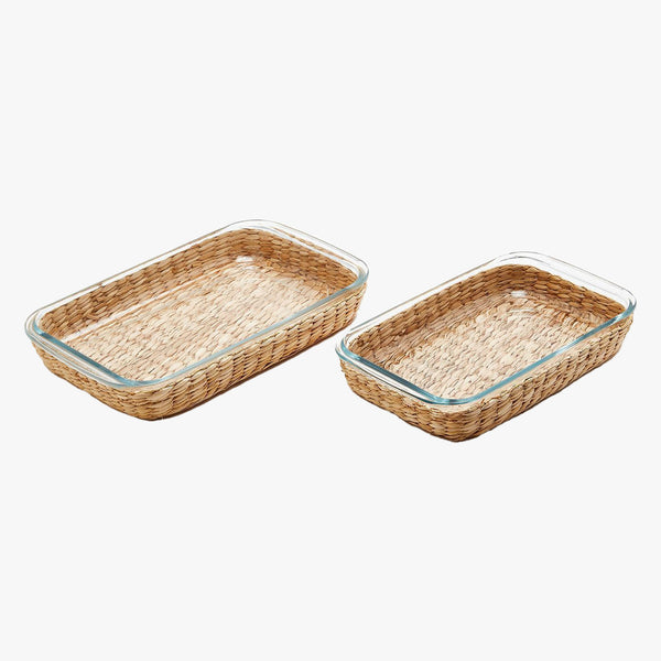Set of two glass baking dishes with removable seagrass sleeve on a white background