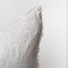 Close up of Light grey stripe linen pillow with slight ridge on a white background