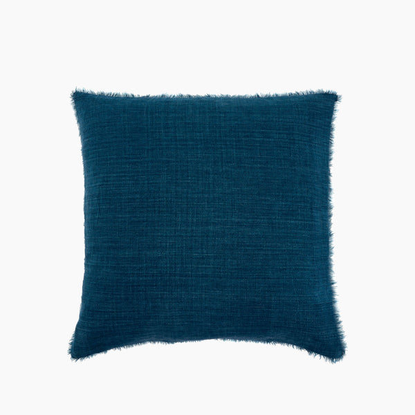 Square blue linen pillow with frayed edges on a white background