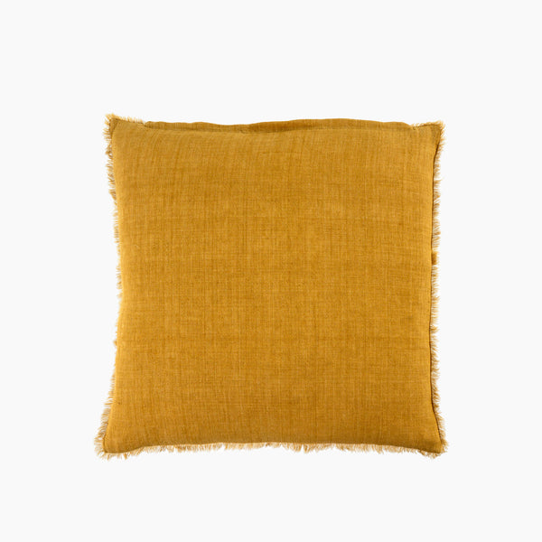 Square mustard yellow linen pillow with frayed edges on a white background
