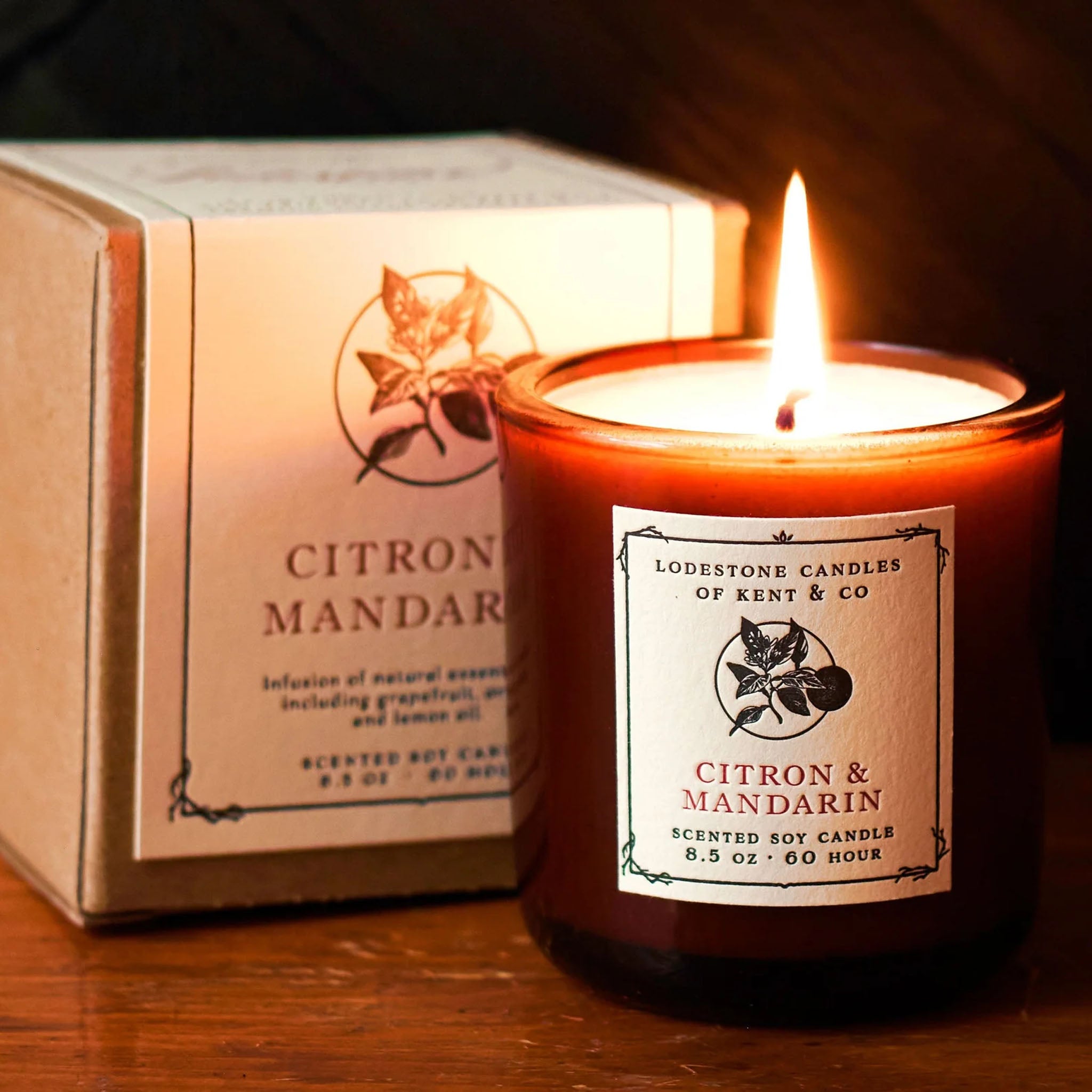 Lodestone Citron & Mandarin Candle on a wood surface next to the unopened candle box showing the label