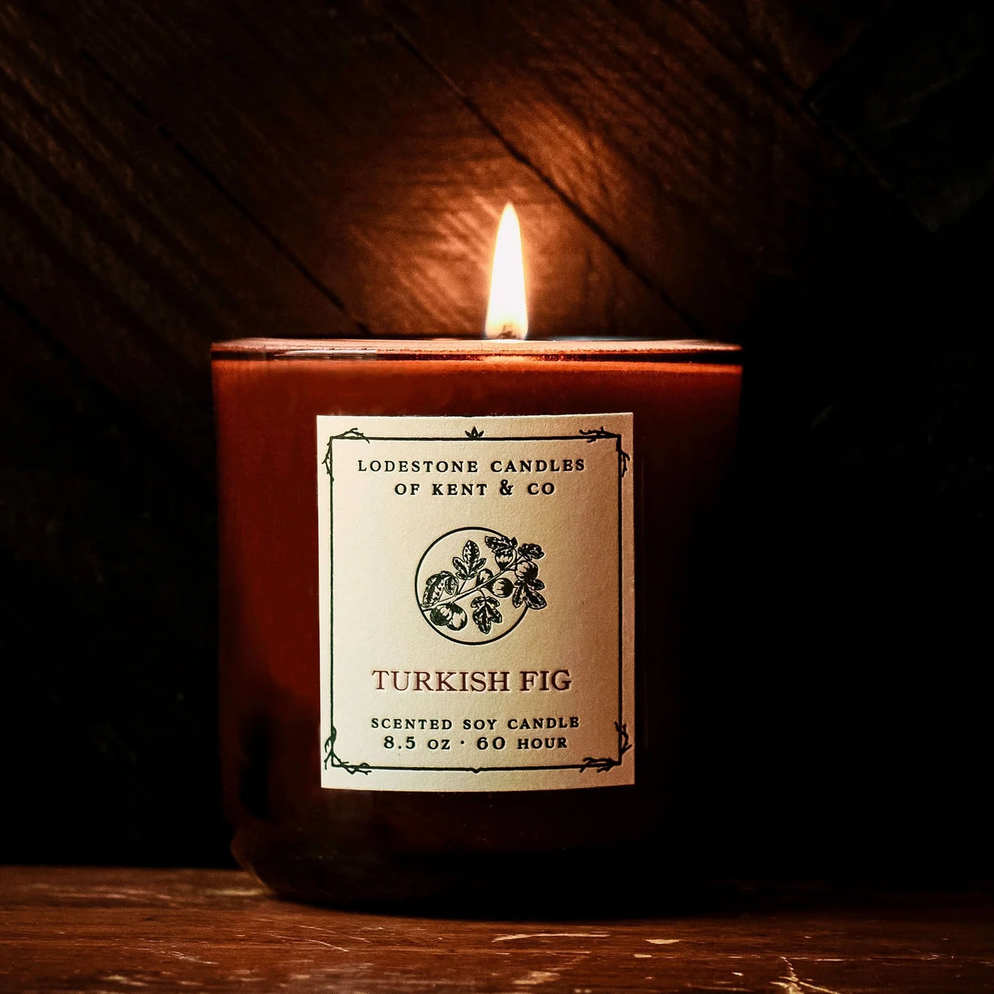 Lit Lodestone Turkish Fig Candle on a wood surface